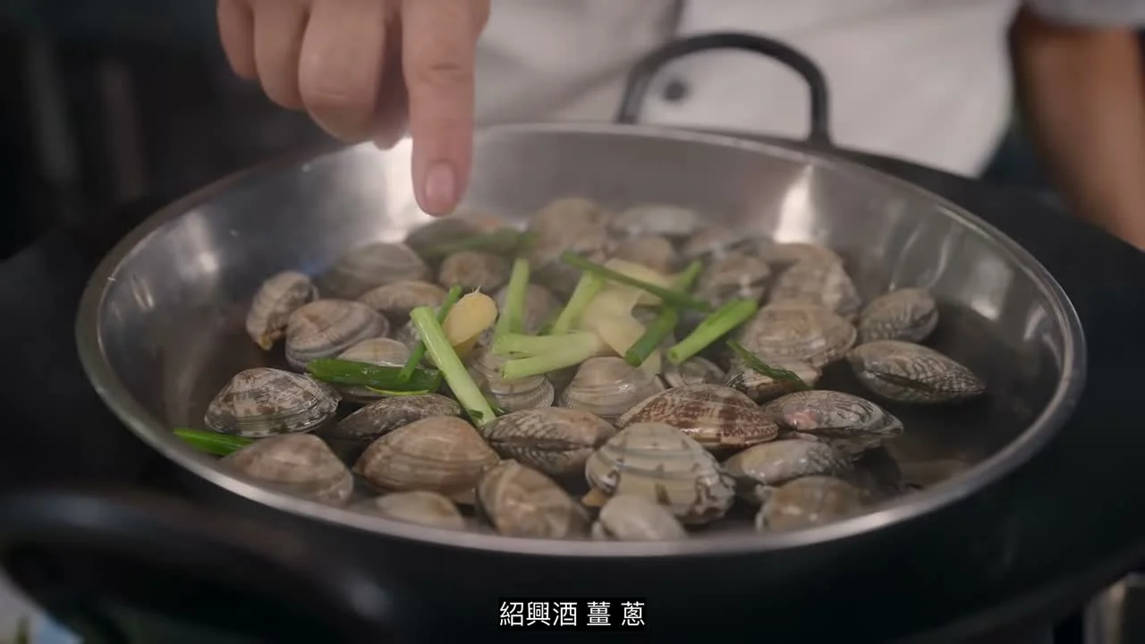 Clams, ginger and spring onion in a steel steaming tray